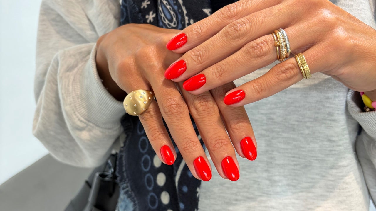 Rode manicure met gouden ringen